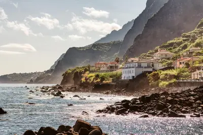 a view of the ocean with houses on a cliff at The Waves Studios by Amazing Madeira in São Vicente