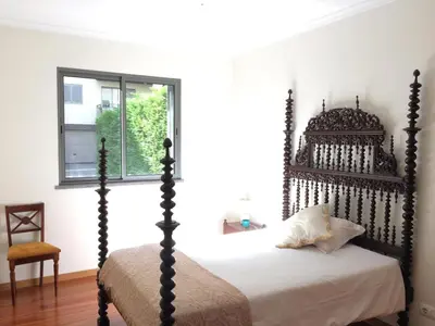a bedroom with a canopy bed and a window at Rochas Shared Apart Garden Refuge in Funchal