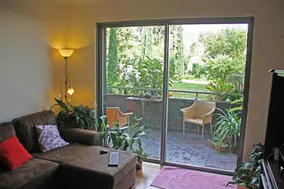 a living room with a couch and a sliding glass door at Rochas Shared Apart Garden Refuge in Funchal