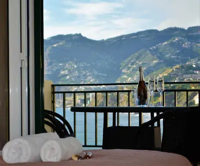 a table with towels and a bottle of wine on a balcony at Golden View by Homie in Funchal