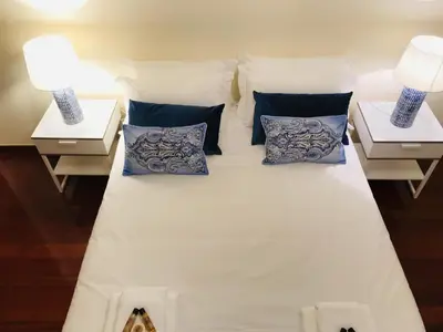 a white bed with pillows and two lamps on tables at Golden View by Homie in Funchal