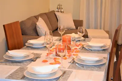 a dining room table with plates and wine glasses at Golden View by Homie in Funchal