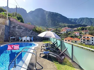 a swimming pool with chairs and an umbrella on a balcony at Villa North Sea by LovelyStay in Ponta Delgada