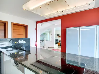 a kitchen with a black counter and a red wall at Villa North Sea by LovelyStay in Ponta Delgada
