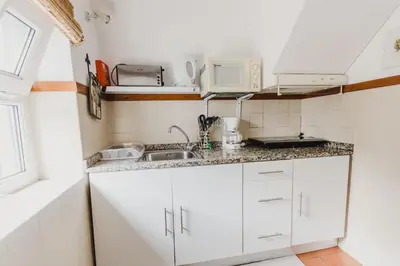 a small kitchen with a sink and a microwave at Casinha do Paiol in Porto da Cruz