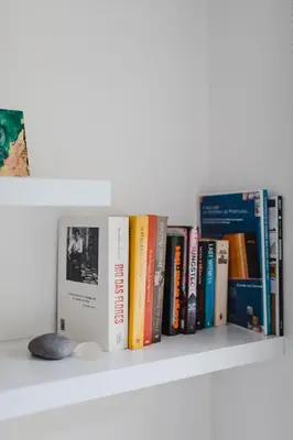 a shelf with a bunch of books on it at O Clube in Porto da Cruz