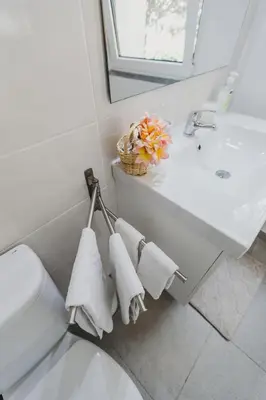 a bathroom with a sink and a toilet and towels at O Clube in Porto da Cruz