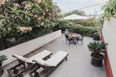 a patio with two chairs and a table and a table and chairs at O Clube in Porto da Cruz