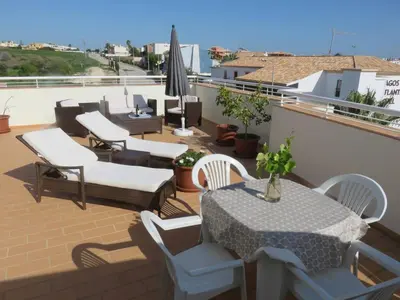 a patio with tables and chairs on a roof at Sweden Apartment - Top Floor one bedroom with sea views - RS in Lagos