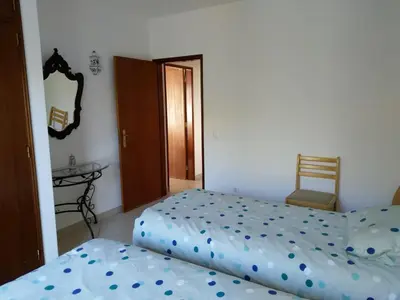 a bedroom with two beds and a sliding glass door at Esti Chamaco - Lagos in Lagos
