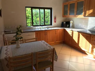 a kitchen with a table and a sink and a window at Esti Chamaco - Lagos in Lagos