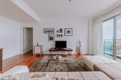 a white living room with a couch and a tv at Cozy T2 with Ocean View in Funchal