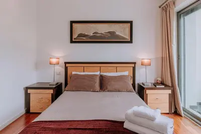 a bedroom with a large bed with two night stands at Cozy T2 with Ocean View in Funchal
