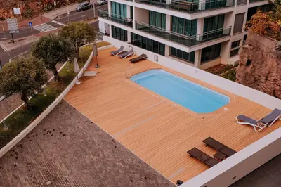 an overhead view of a wooden deck with a swimming pool at Cozy T2 with Ocean View in Funchal
