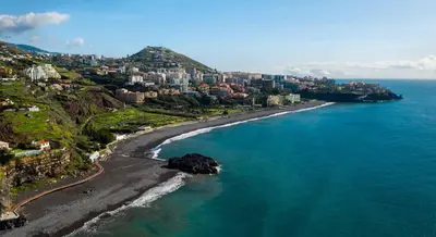 an aerial view of a beach with buildings and the ocean at Cozy T2 with Ocean View in Funchal