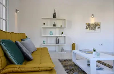 a living room with a yellow couch and a rug at Mansion Almond - SEA, SUN and a charming refuge! in Paul do Mar