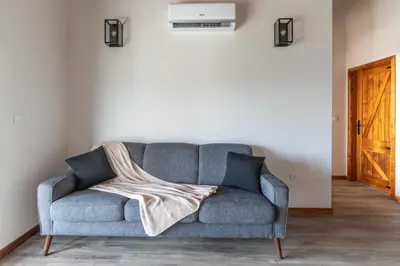 a blue couch in a living room with a blanket on it at Rochão Village by Rent2U, Lda in Calheta