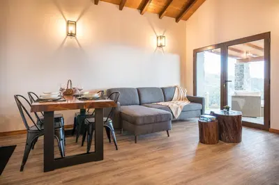 a living room with a couch and a table at Rochão Village by Rent2U, Lda in Calheta