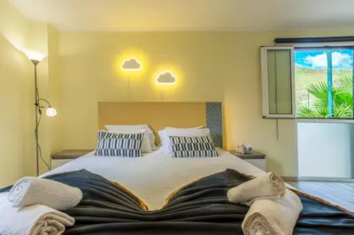 a bedroom with a large bed and a window at Mateus House - Porto da Cruz Center in Porto da Cruz