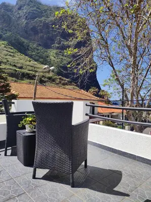 a patio with a table and chairs and a mountain at Mateus House - Porto da Cruz Center in Porto da Cruz