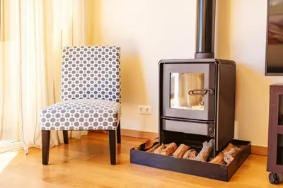 a room with a chair and a wood stove at Madeira Offline by Amazing Madeira in Ponta Delgada