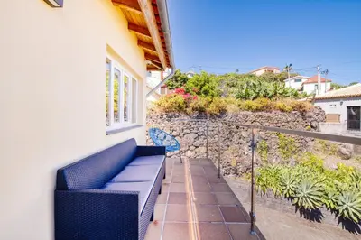 a balcony with a blue bench on a house at Madeira Offline by Amazing Madeira in Ponta Delgada