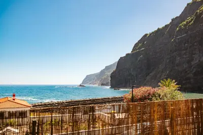 a view of the ocean from behind a fence at Madeira Offline by Amazing Madeira in Ponta Delgada