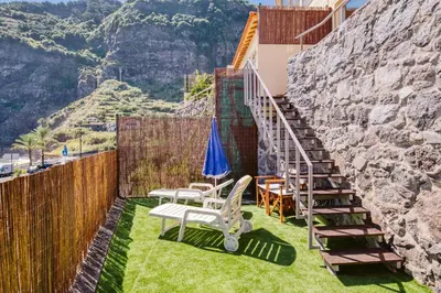 a patio with a staircase and a table and chairs at Madeira Offline by Amazing Madeira in Ponta Delgada