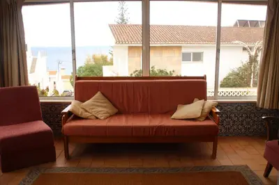 a couch sitting in front of a large window at Amazing Beach House in Algarve with Sea View! in Luz