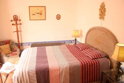 a bedroom with a bed with a striped blanket at Amazing Beach House in Algarve with Sea View! in Luz
