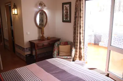 a bedroom with a bed and a chair and a mirror at Amazing Beach House in Algarve with Sea View! in Luz