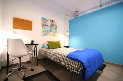 a bedroom with a bed and a desk and a chair at The Waves Hostel by Amazing Madeira in São Vicente