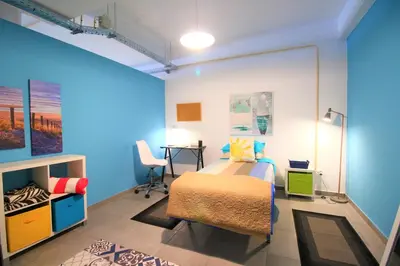 a bedroom with a bed and a desk in it at The Waves Hostel by Amazing Madeira in São Vicente