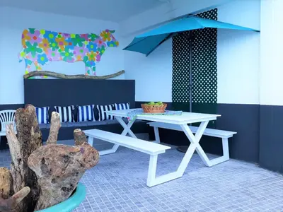 a white picnic table and bench in a room at The Waves Hostel by Amazing Madeira in São Vicente
