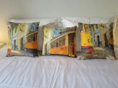 four pillows on a bed with a painting of a bus at Market Downtown T3 in Funchal