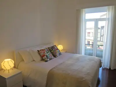 a bedroom with a white bed with a window at Market Downtown T3 in Funchal