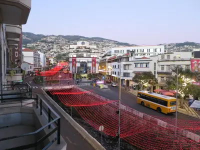 a yellow school bus driving down a city street at Market Downtown T3 in Funchal