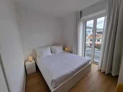 a bedroom with a white bed and a large window at Market Downtown T3 in Funchal