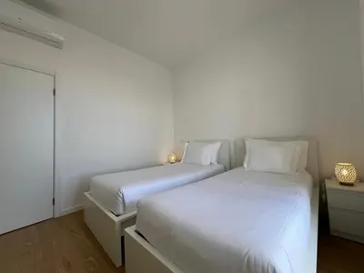 two beds in a bedroom with white walls at Market Downtown T3 in Funchal