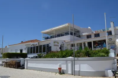 a white building with a fence in front of it at OCEAN VIEW VILLA BELAMAR in Luz