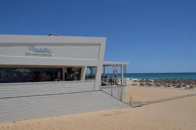 a building on a beach with the ocean in the background at OCEAN VIEW VILLA BELAMAR in Luz