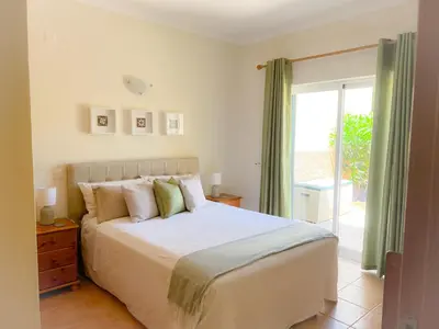 a bedroom with a bed and a sliding glass door at OCEAN VIEW VILLA BELAMAR in Luz