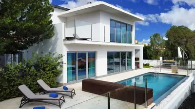 a house with a swimming pool and two chairs at Villa Madeira by LovelyStay in Caniço