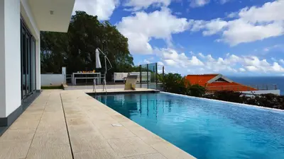 a swimming pool with a view of the ocean at Villa Madeira by LovelyStay in Caniço