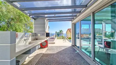 a house with a balcony with a view of the ocean at Villa Madeira by LovelyStay in Caniço
