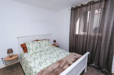 a white bedroom with a bed and a window at Fortaleza do Pico Apartment in Funchal