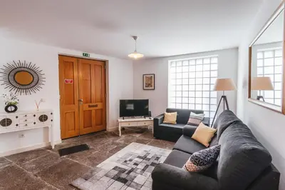 a living room with a couch and a television at Fortaleza do Pico Apartment in Funchal