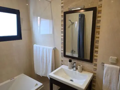 a bathroom with a sink and a mirror and a shower at Quintinha do Álvaro - Holiday house in Santana
