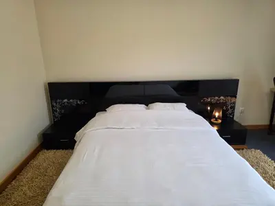 a bedroom with a large white bed with a black headboard at Quintinha do Álvaro - Holiday house in Santana