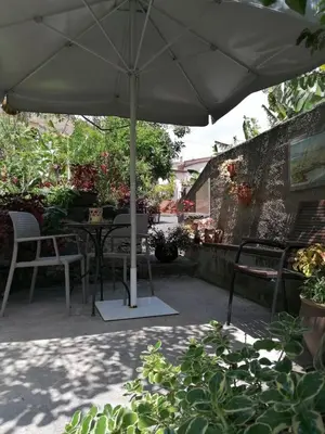 a patio with a table and chairs and an umbrella at Casa do pescador in Machico